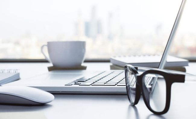 laptop, glasses and mug on desk
