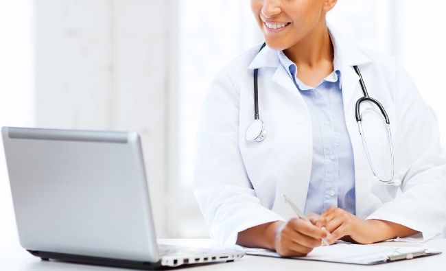 Doctor on laptop working on LinkedIn profile - LinkedIn for Doctors